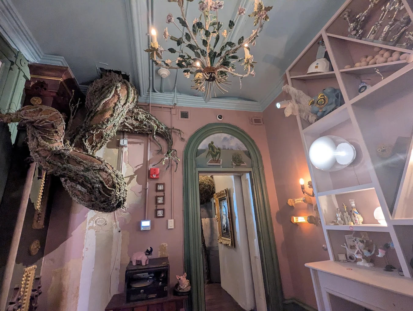 Sculptural roots and accent-lit display shelves in a parlor room at Ministry of Awe Philadelphia