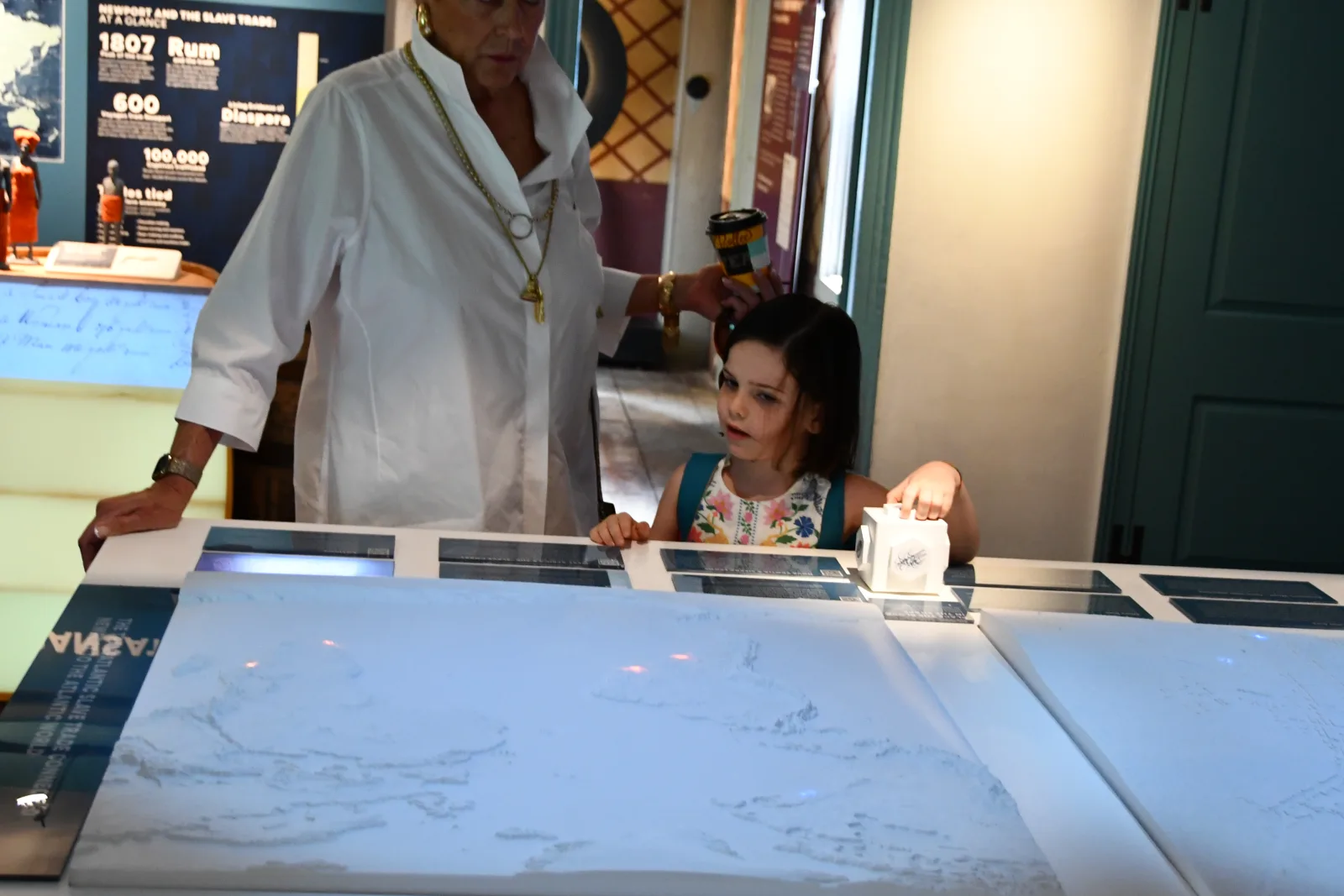 Visitors exploring the RFID interactive map table in the Newport and the Slave Trade exhibit at the Center for Black History