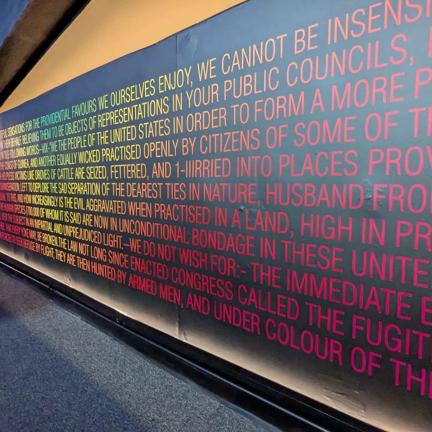 Text of the Absalom Jones 1799 petition to Congress printed in gradient color along the hallway walls